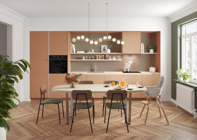 Cette cuisine américaine moderne s'ouvre sur une salle à manger lumineuse, combinant des meubles corail et bois clair.